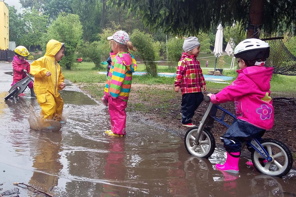 Kids plaing in the school garden in the rain